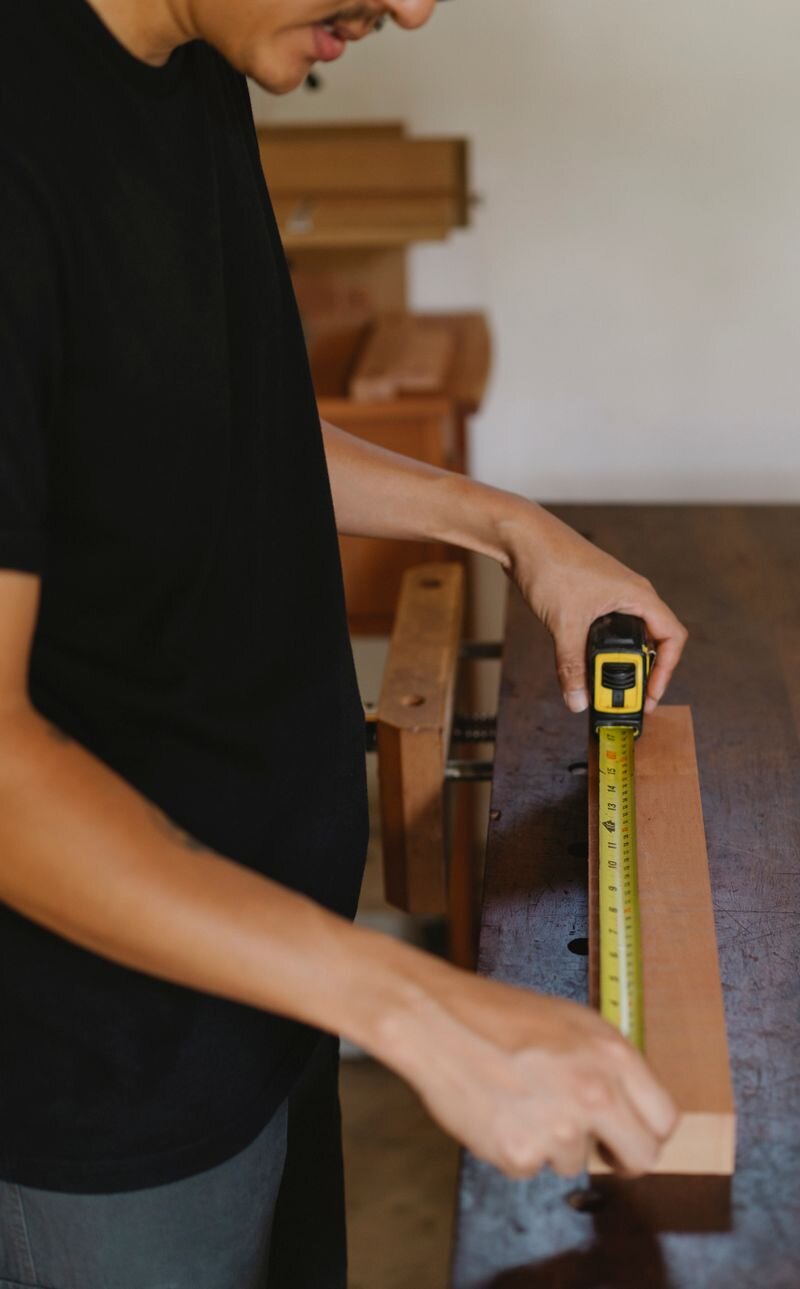 Carpenter measuring wood in a workshop