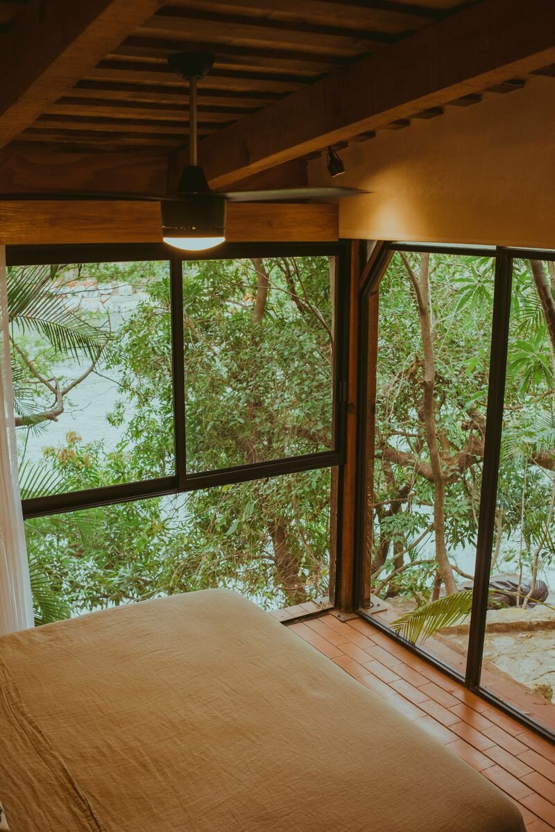 Wood-lined cottage bedroom with a lake view