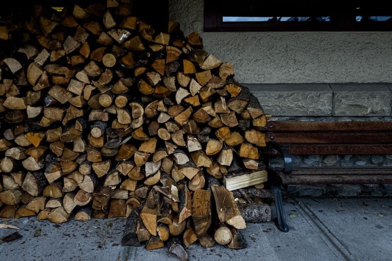 Firewood neatly stacked beside a building